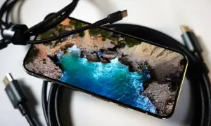 Smartfon z widokiem na ocean, gotowy do przesyłania obrazu na TV przez USB-C.