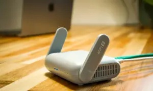 Router Wi-Fi 6 z antenkami, obok laptopa. Czy wiesz, upnp co to jest i jak ułatwia połączenia?