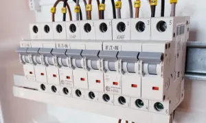 Rzędy bezpieczników w rozdzielnicy elektrycznej, różne rodzaje bezpieczników i ich oznaczenia.