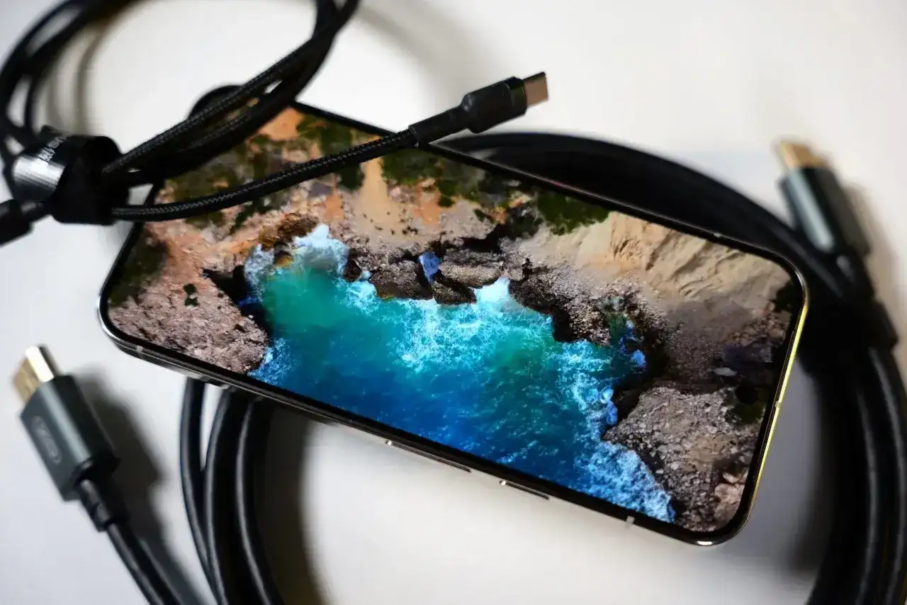Smartfon z widokiem na ocean, gotowy do przesyłania obrazu na TV przez USB-C.