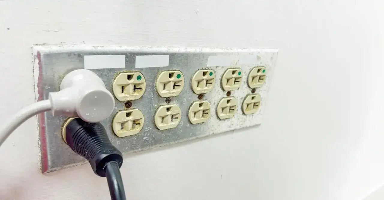 Podłączenie gniazdka: dwa kable wpięte w listwę z ośmioma gniazdami elektrycznymi.