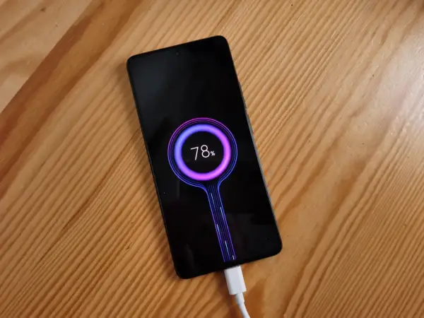 Smartfon z 78% baterii, podłączony białym kablem, pokazuje animację **szybkiego ładowania** na czarnym ekranie.