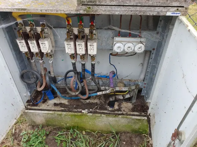 W skrzynce elektrycznej widoczne są bezpieczniki i przewody. To miejsce wymaga przeglądu, by potwierdzić oświadczenie o gotowości instalacji przyłączanej.