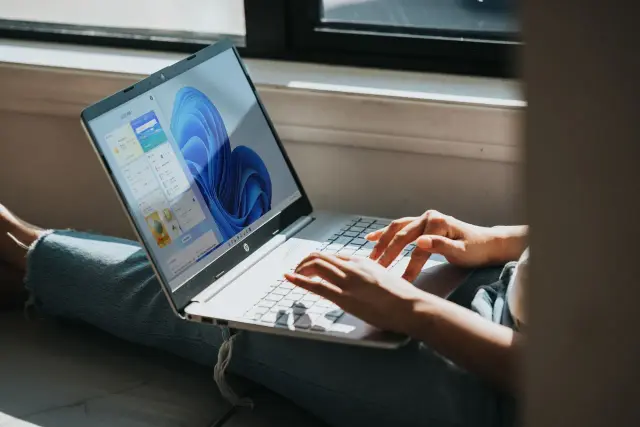 Osoba pracuje na laptopie z systemem Windows 11, szukając informacji, jak zmienić nazwę użytkownika Windows 11.