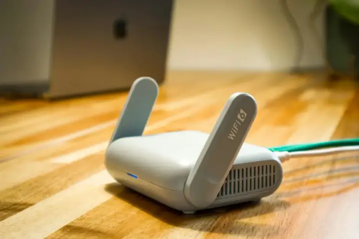 Router Wi-Fi 6 z antenkami, obok laptopa. Czy wiesz, upnp co to jest i jak ułatwia połączenia?